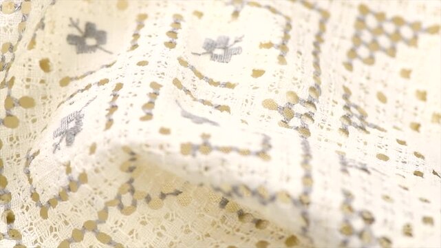 Cross stitch on linen fabric, handmade cross-stitch texture background, lace, natural eco folded linen tablecloth. Bio textile material backdrop, canvas top view, close up, rotating. 