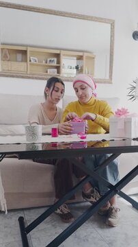 Daughter supporting mother with cancer wrapping gifts