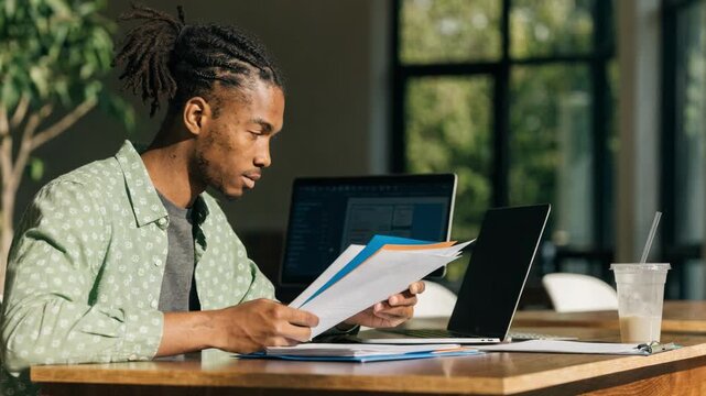 A student reviewing financial aid documents before uploading them to an online lending profile with dashboard interface softly blurred behind.