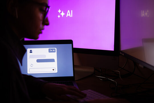 Young woman writing AI promt in a modern office.