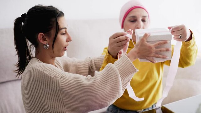 Supportive daughter prepare a present with mother with cancer