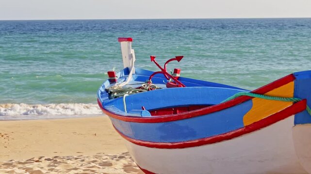 Colorful traditional fishing boat resting on a sandy beach in the algarve region of portugal, with gentle turquoise ocean waves lapping the shore on a sunny day, embodying tranquility and travel