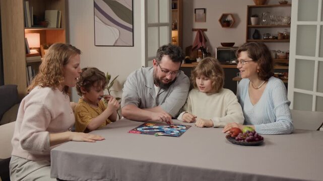Multigenerational Caucasian family playing board game, celebrating victory with raised hands. Ideal for family leisure advertisements or domestic entertainment campaigns