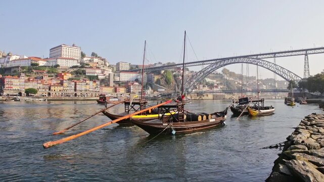 Typical rabelo boats. Traditional portuguese cargo vessels. Floating on the douro river with the historic city of porto and the dom luis i bridge creating a picturesque and famous european landscape