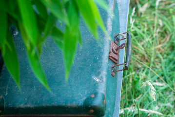 Vintage suitcase in green grass with leaf shadows for travel memories and adventure themes © Hanna