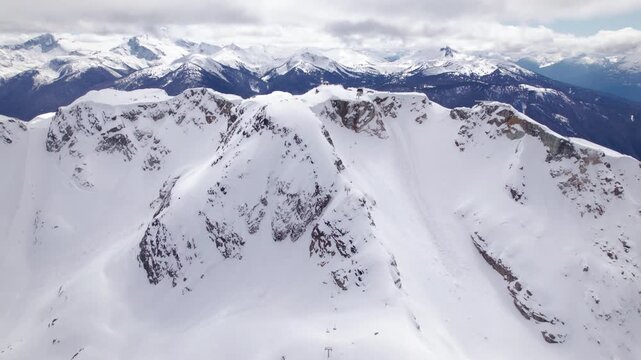 Aerial drone view of Whistler ski resort alpine terrain and snow-covered mountain peaks, British Columbia. PRORES
