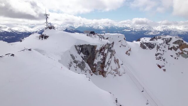 Aerial drone view of Whistler ski resort alpine terrain and snow-covered mountain peaks, British Columbia. PRORES