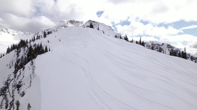 Aerial drone view of Whistler ski resort alpine terrain and snow-covered mountain peaks, British Columbia. PRORES