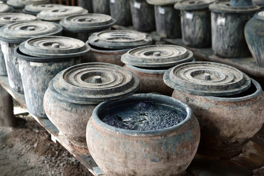 Fermenting natural indigo dye vat ready for hand-dyeing textiles in Sakon Nakhon, Thailand. Authentic craft.