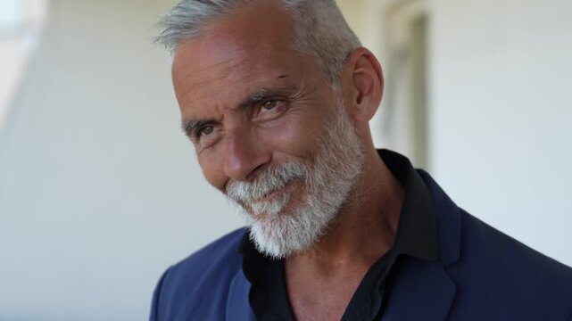 Cinematic portrait of a mature silver haired gentleman removing his hat, confident elegant man representing personal style, experience, authenticity and modern masculine lifestyle