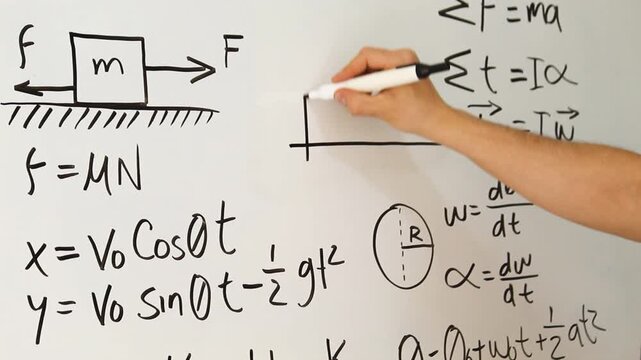 Detailed view of a male drawing a diagram on an acrylic whiteboard with a physics equations and concepts