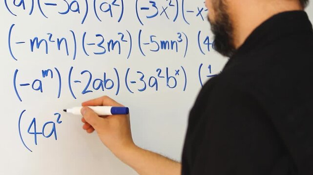 Detailed view of a male solving algebraic equations on an acrylic whiteboard