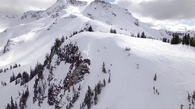 Aerial drone view of Whistler ski resort alpine terrain and snow-covered mountain peaks, British Columbia