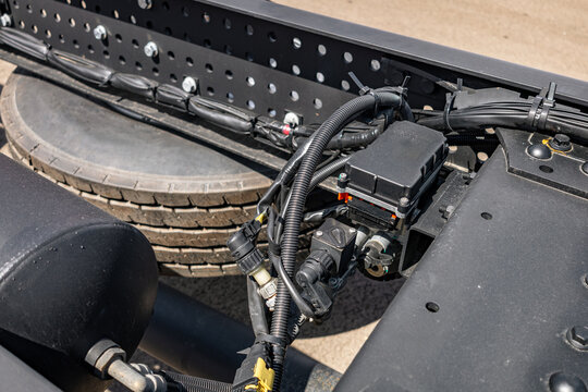 Semi truck chassis EBS brake control valve valve module. Modern commercial heavy duty transport vehicle air pneumatic system component on frame with long haul tractor technical engineering details.