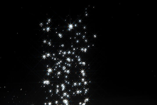 Shining water created sparkling splash with bright reflections and starburst flare, like  star in light. Water Glitter from splash caught light, creating abstract sparkling scene with star flare