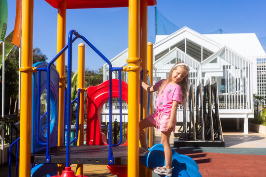 Young girl playing on a playground slide
