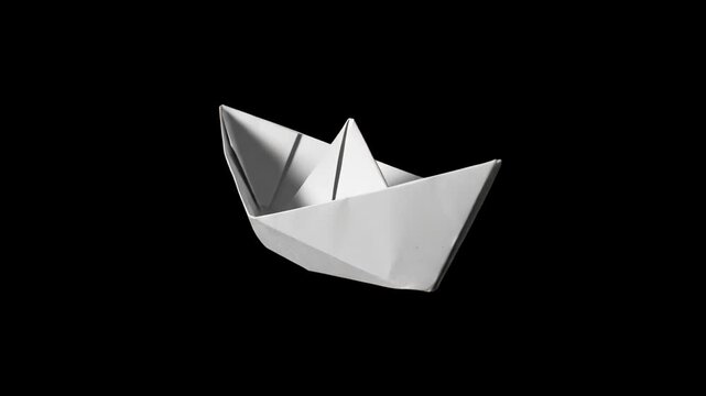 A classic folded white origami paper boat floating against a dark black background. Great for concepts of journey, childhood, minimalism, startup ideas, and visual effects overlays.