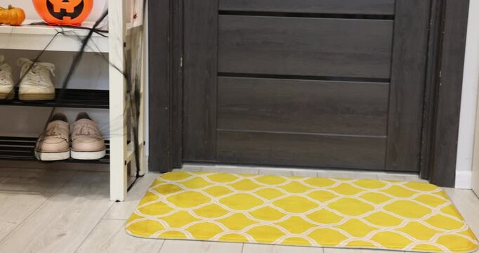 Stylish patterned doormat on floor near entrance indoors. Camera moving left
