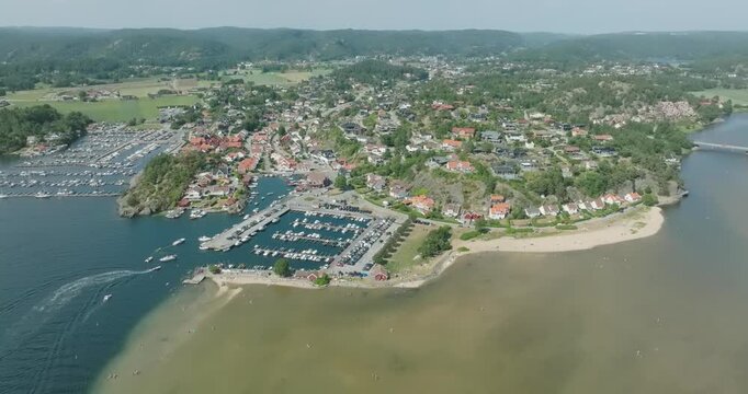 Aerial view of coastal marina and residential area in H&oslash;llen Norway in slow motion