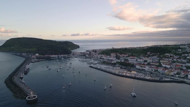 Horta Marina at sunset on Faial Island, Azores, Portugal, showing the harbour, waterfront, moored boats and warm evening light over the Atlantic Ocean, aerial