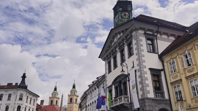 Ljubljana Town Hall on Mestni trg with its clock tower, Robba Fountain and Ljubljana Cathedral towers behind the busy old town square.