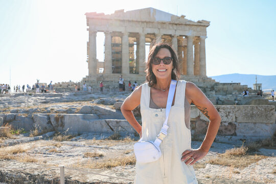 Woman posing in front of the Parthenon on the Acropolis in Athens, Greece.