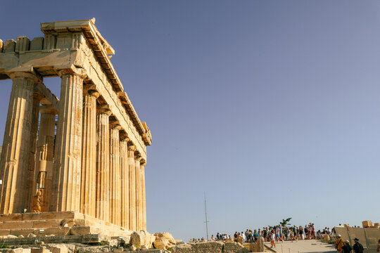 Side view of the Parthenon with visitors on the Acropolis in Athens, Greece.