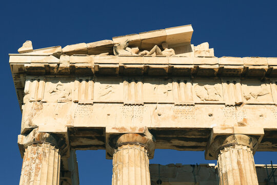 Detailed view of the Parthenon facade featuring carved stone reliefs and Doric columns in Athens, Greece.
