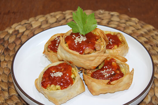 Crispy Fried Wonton Dumplings with Spicy Chili Sauce and Sesame Seeds