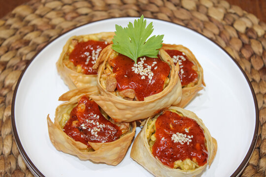 Delicious Crispy Fried Dumplings Served with Spicy Chili Sauce and Sesame Seeds