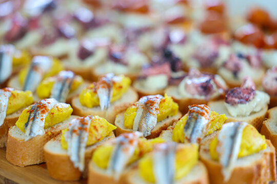 Selective focus on gourmet seafood canap&eacute;s served on toasted bread at a catered gathering.