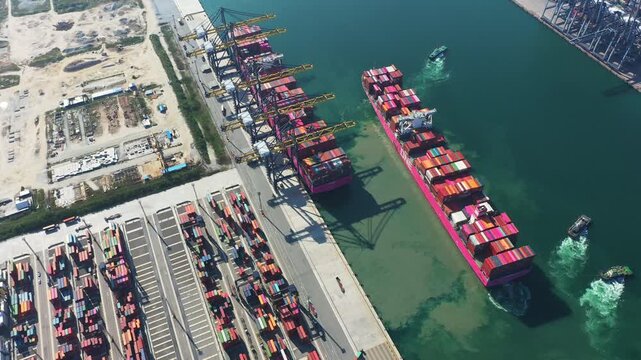 Large container ship maneuvers within busy Port as cargo is unloaded onto the waterfront; Ship transporting valuable Cargo at modern seaport during international trade operations.