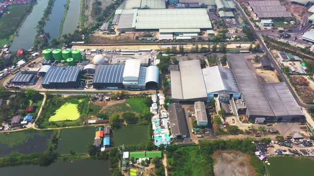 Large industrial complex showcases expansive manufacturing buildings set within tranquil rural waterway landscape-ideal for business, industry, property photography, logistics solutions.