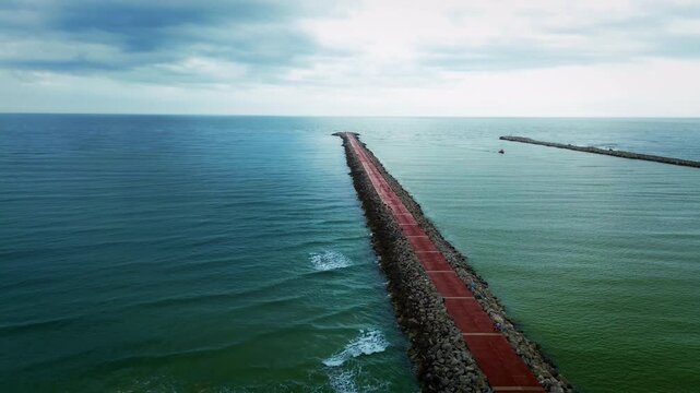 Aerial dawn footage of Panuco River opening from Gulf of Mexico showing vessel passing through breakwaters with turquoise and green waters