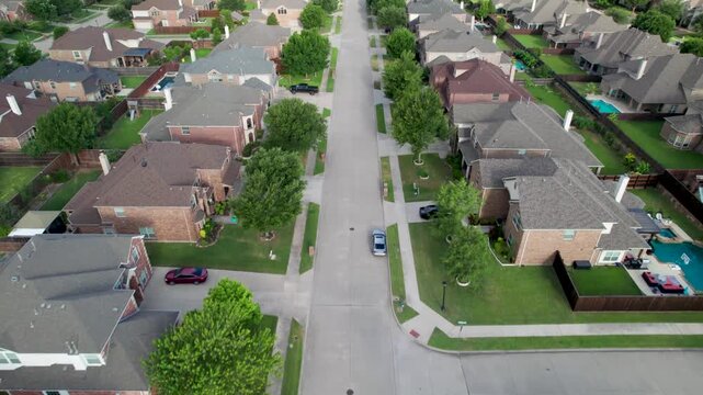 Aerial video of a neighborhood in Frisco Texas, flying over Holly Tree Ln. heading west