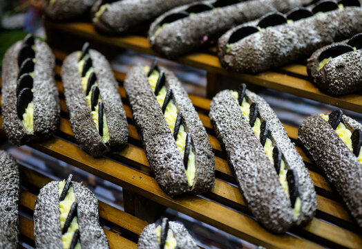 A bunch of chocolate cream-filled breads lined up