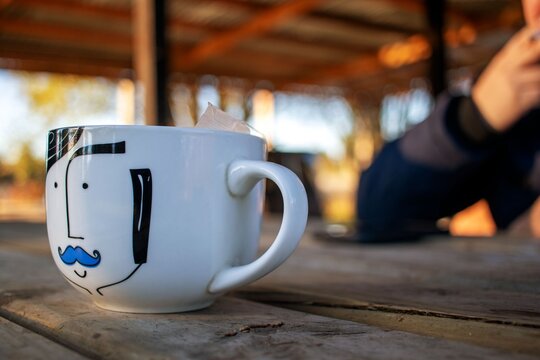 Close-up of a tea cup on a rustic table with warm blurred background