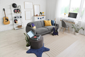 Modern living room interior with musical instruments, comfortable gray sofa, and white brick wall decor © Pixel-Shot