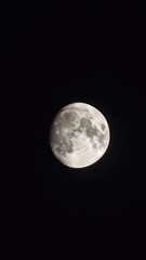 Naklejka premium Close up of the full moon glowing brightly in the dark night sky showing detailed lunar craters and surface texture against a pitch black background for astronomical concept