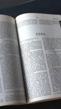 Opening to the Book of Ezra of the Old Testament in the Holy Bible. New Revised Standard Version. Vertical video.