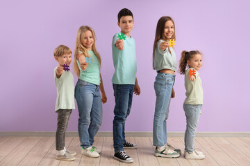 Fototapeta premium Group of cute kids with hashtags on lilac background