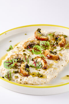 Green buckwheat porridge crowned with glazed eel, chopped pistachios and red sorrel beneath ample copy space
