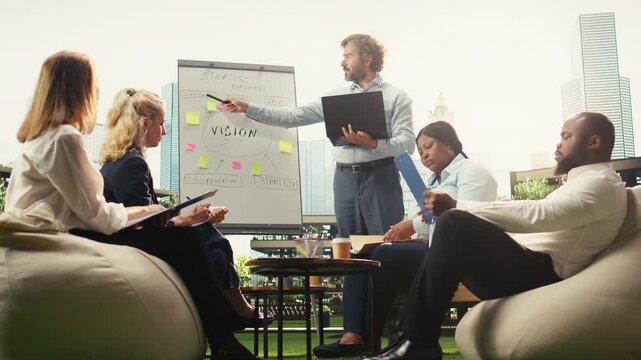 Businessman presenting ideas on whiteboard during informal discussion, smiling and pointing to sticky notes for action plan implementation, reviewing strategy.