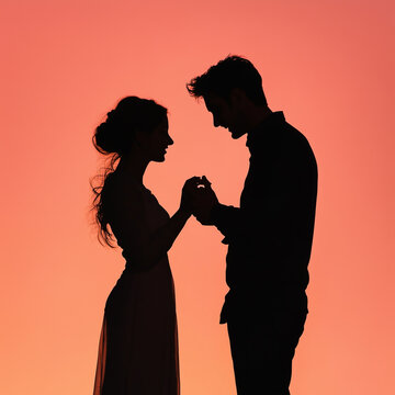 Romantic marriage proposal with couple holding hands. Intimate silhouette of man proposing to woman at sunset.