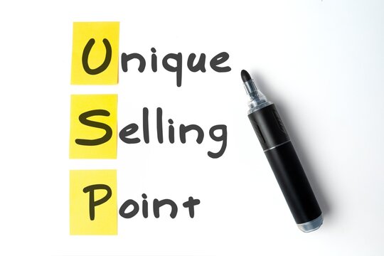 Unique Selling Point acronym written with a black marker on yellow sticky notes and a white background. Business strategy, marketing, sales advantages concept.