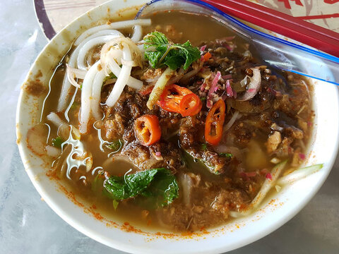 Delicious Malaysian Penang Asam Laksa Noodle Soup with Fish Broth and Fresh Herbs