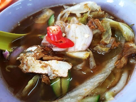 Close Up Bowl of Malaysian Asam Laksa with Spicy Broth and Vegetables