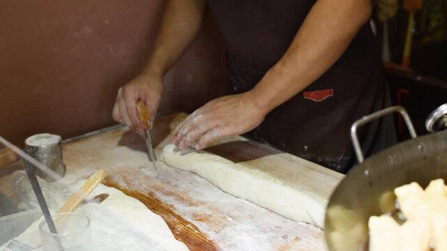 Asian Baker Using Bench Scraper to Prepare Dough for Bread