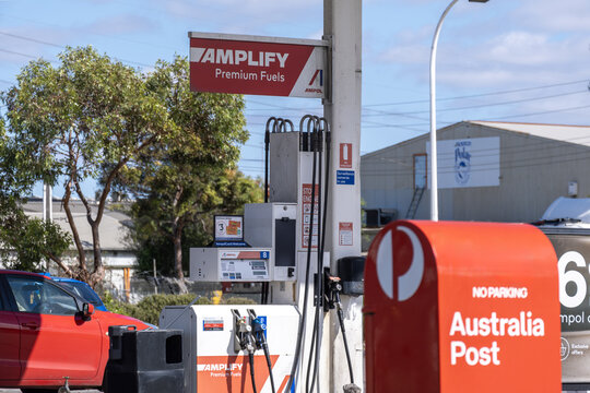 Ampol Amplify premium fuel pump signage beside an Australia Post mailbox at a suburban service station, Melbourne, Australia