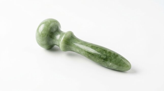 A single green jade facial massage tool isolated on a white background for spa and beauty treatments